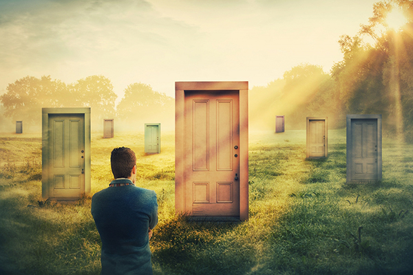 A man stands in front of many different doors, wondering which to walk through.
